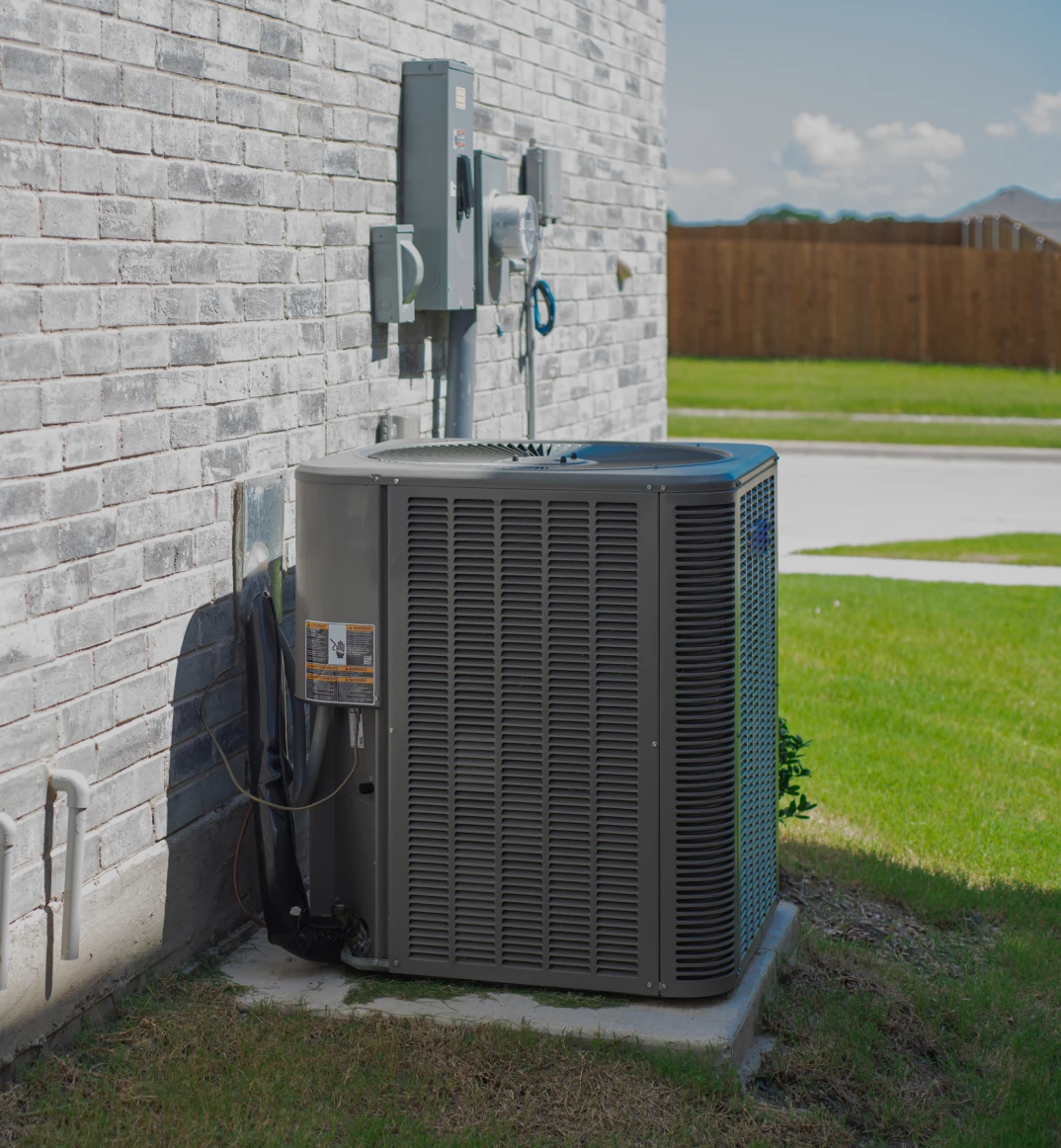 Outdoor air conditioning unit beside brick wall.